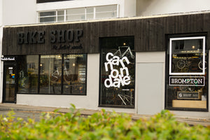 Rockets and Rascals Bike Shop storefront in Poole with large windows, dark wood signage, and a visible 'BROMPTON'  and 