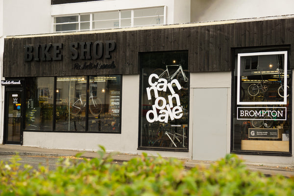 Rockets and Rascals Bike Shop storefront in Poole with large windows, dark wood signage, and a visible 'BROMPTON'  and 