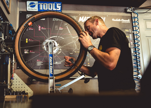 Professional bicycle mechanic builds a custom bicycle wheel set for a custom dream build bike in the workshop at Rockets and Rascals Poole, Dorset.